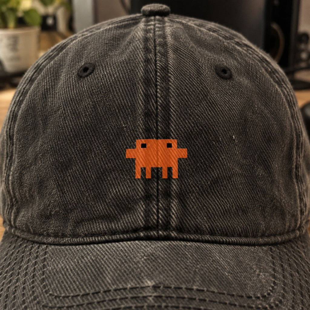Close do Pixelguejo no boné preto: caranguejo de pixel laranja pequeno entre os ilhoses