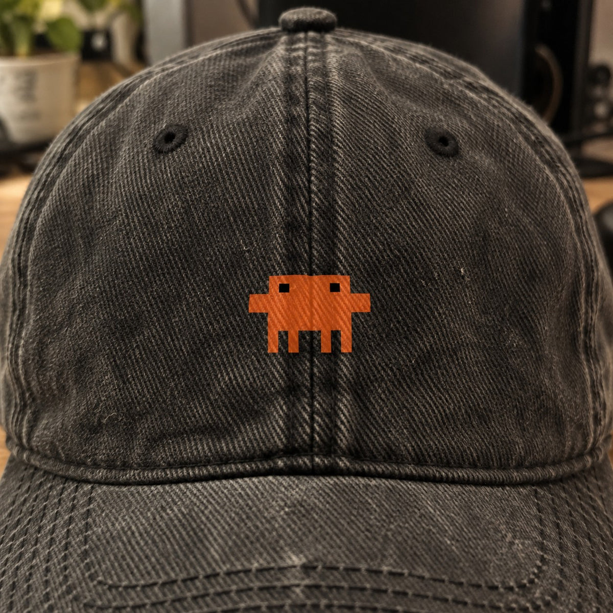Close do Pixelguejo no boné preto: caranguejo de pixel laranja pequeno entre os ilhoses